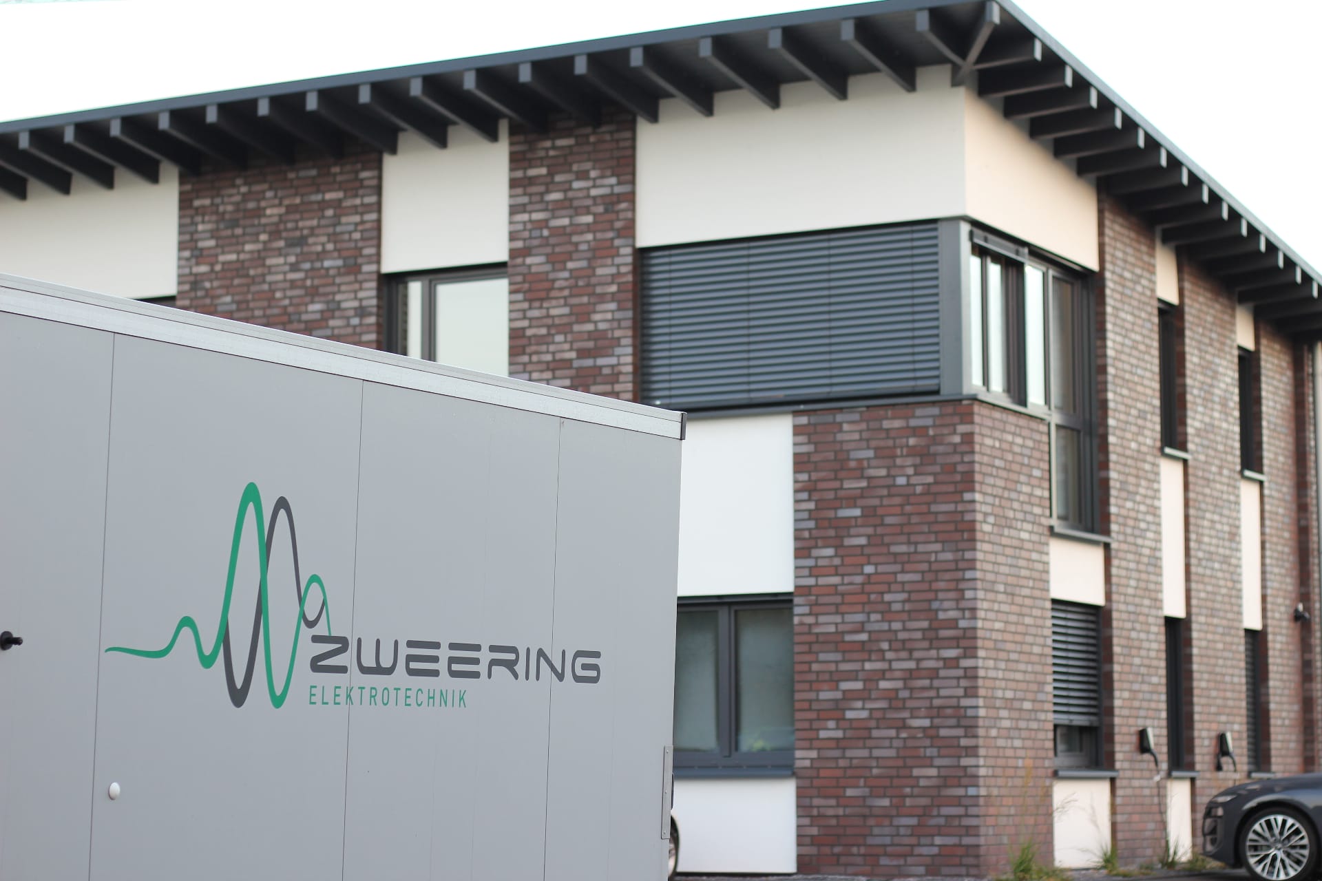 Zweering Elektrotechnik Firmengebäude und Fahrzeug mit Logo